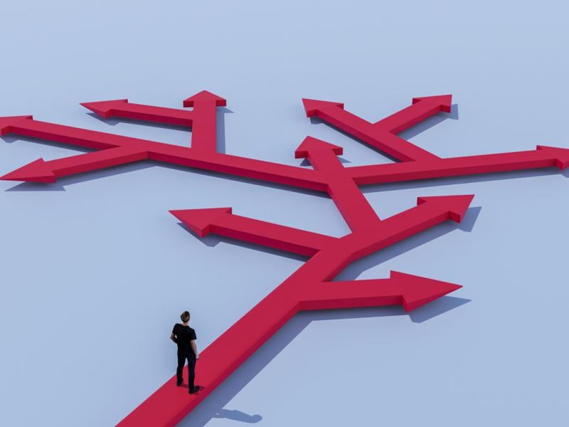 Figure stands at paths in different directions