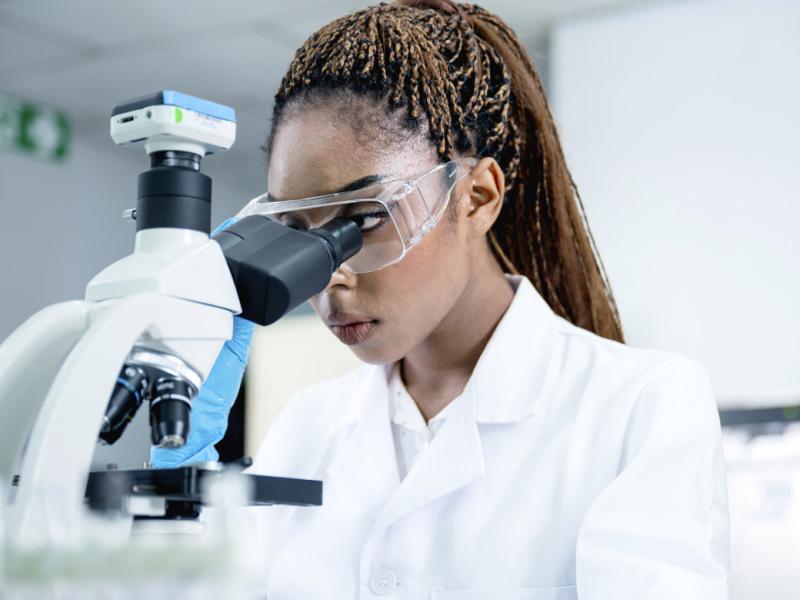 Scientist in a lab using a microscope