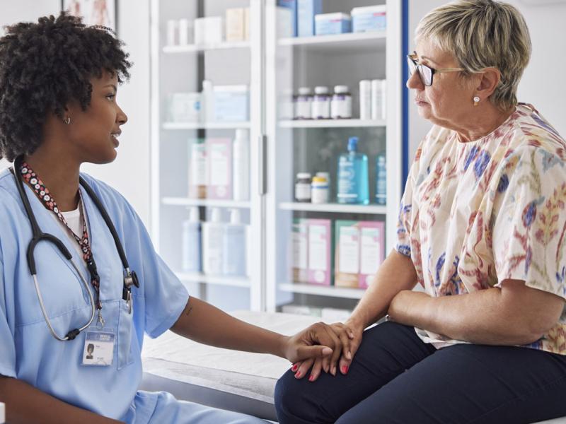 Physician with reassuring hand on patient