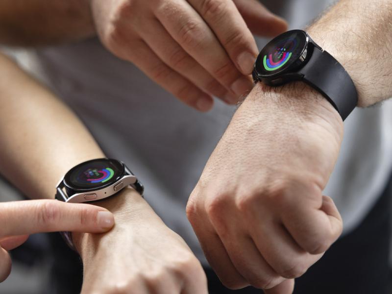 Fingers point to activity trackers on smartwatches