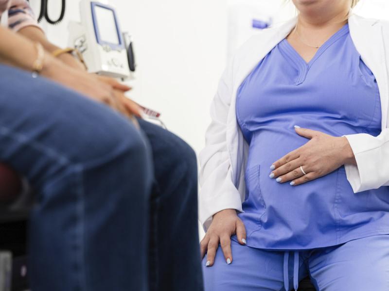 Pregnant physician with a patient