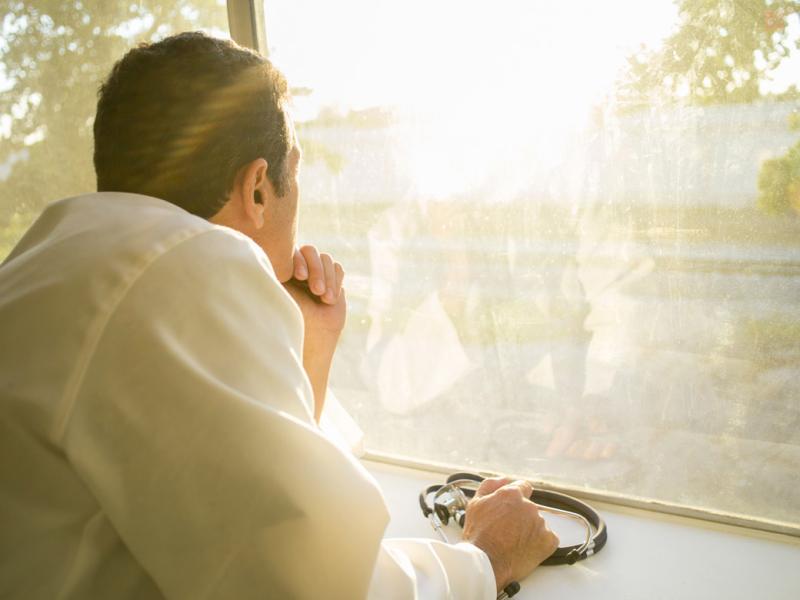 Physician looks out a window