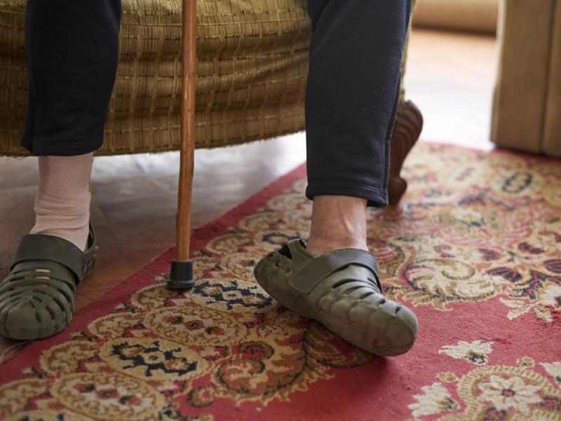 Two feet, one of them injured and bandaged, with a walking cane