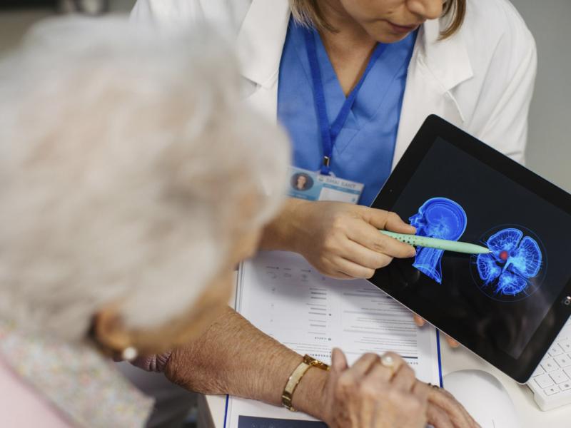 Doctor explaining results of MRI scan of brain to senior patient