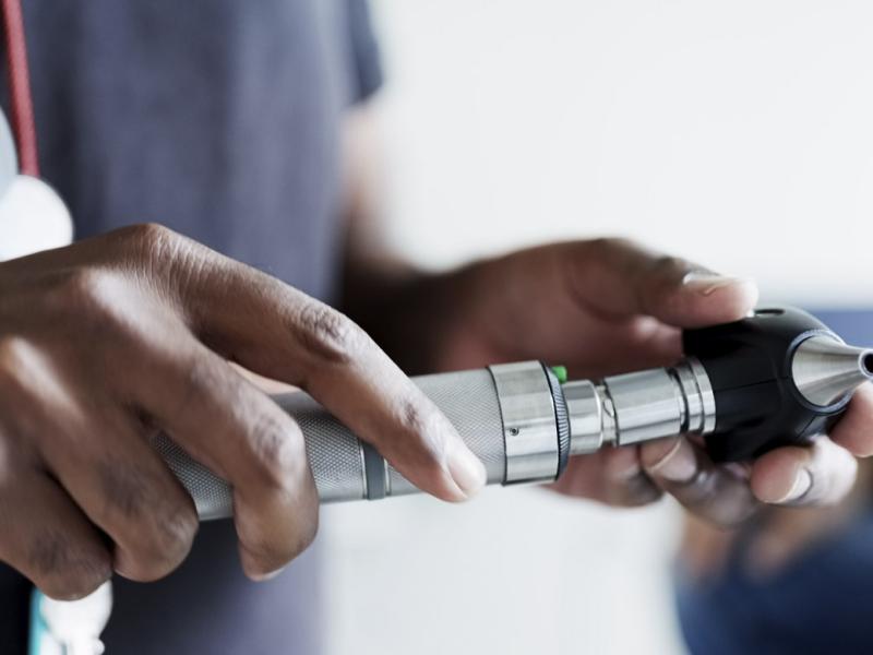 Physician holding otoscope