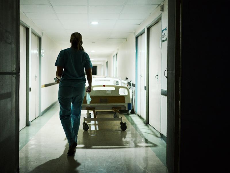 Physician walks through a dimmed hallway