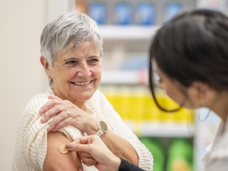 Healthcare worker places bandage on smiling patient