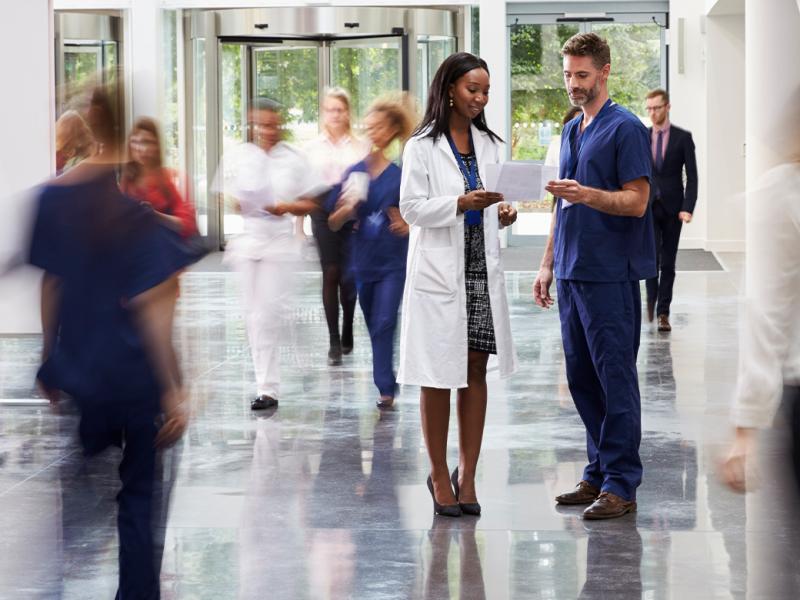 Two physicians in a busy hallway