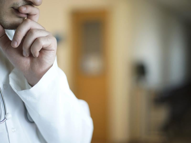 Thoughtful doctor with hand on chin