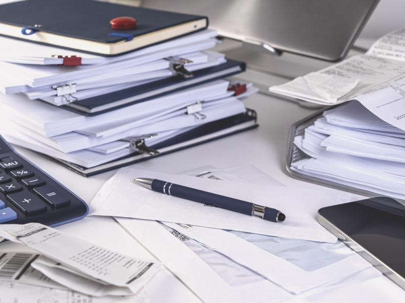 Stacks of documents, calculator, pen and smartphone