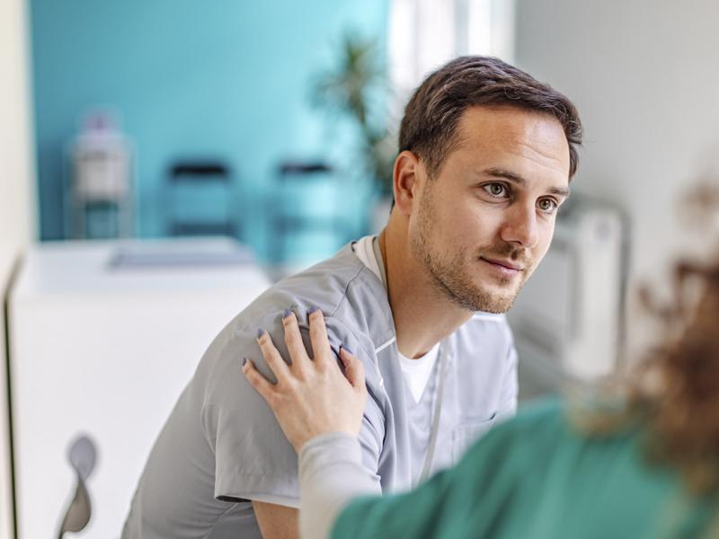 Healthcare worker with hand on patient's shoulder