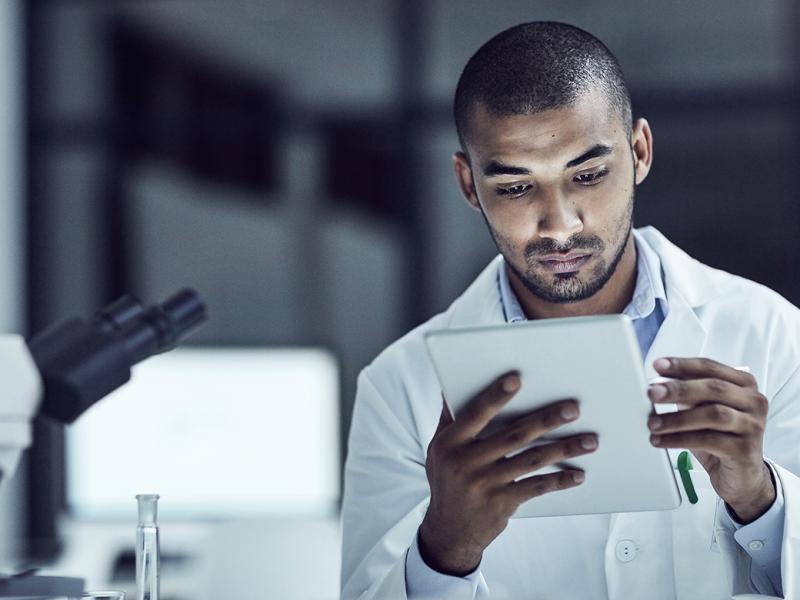 A young male physician studies in a laboratory setting.