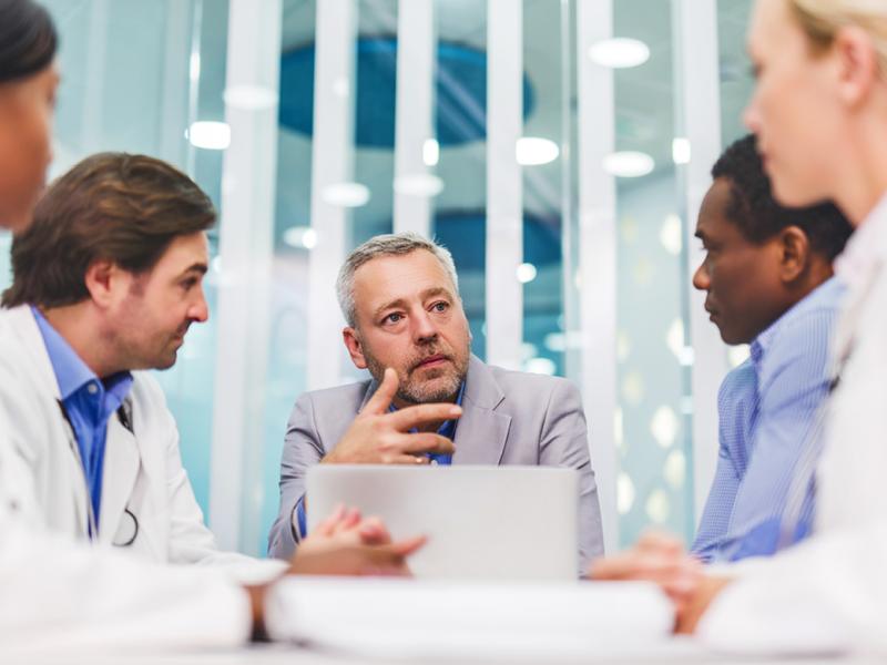 Group of physicians gathered around a computer.