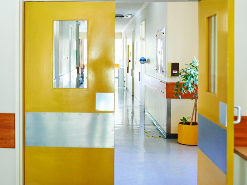 Door from a hospital room opening to a hallway.