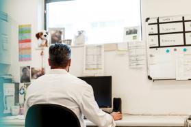 Back of man working at a desktop computer