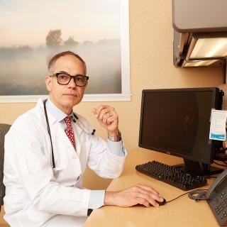 Photo of Nigel Girgrah, MD, in his medical office.
