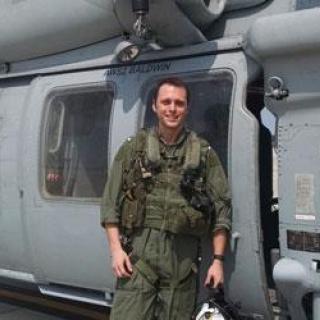 Josh Lesko, MD, flight surgeon-in-training in front of miltary helicopter