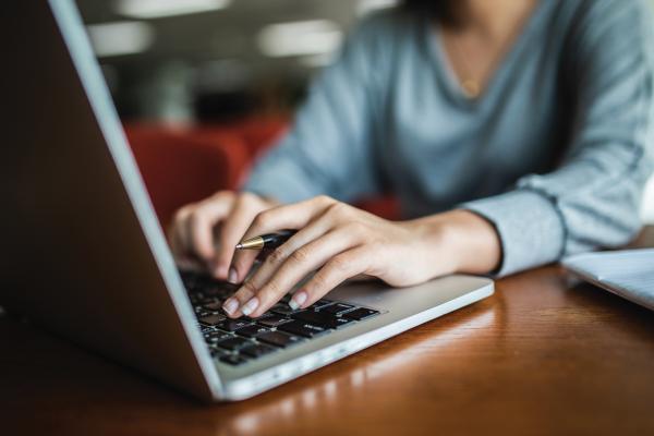 Closeup of woman's hand on a laptop
