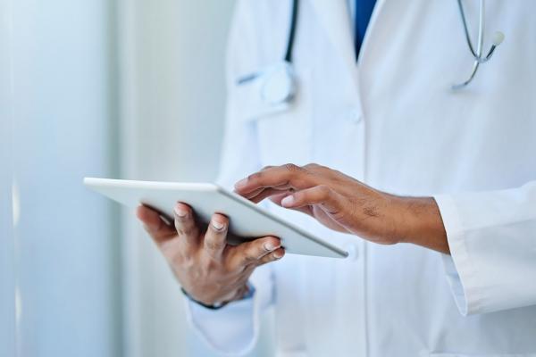 Tight shot of physician scrolling on a tablet