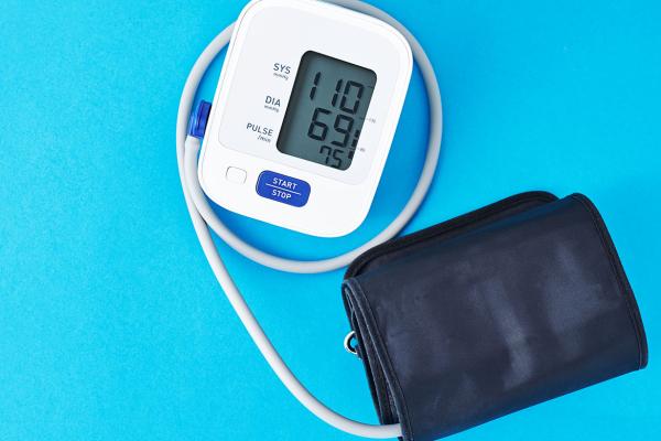 Tight shot of a personal blood pressure measuring device and carrying case on a blue background