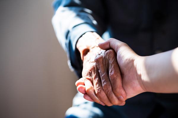 Close up of elderly person's hand shaking another person's hand