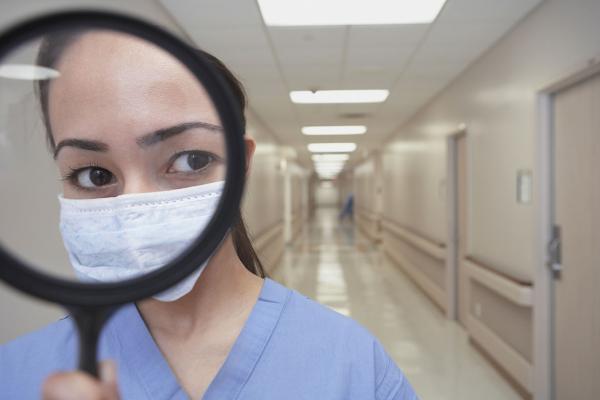 Health care worker holding a magnifying glass