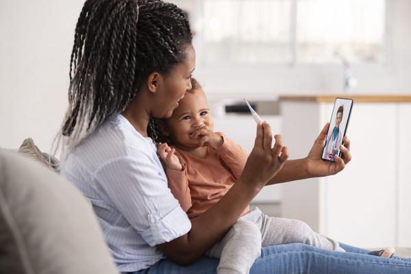 Woman holding baby while in a telehealth appointment
