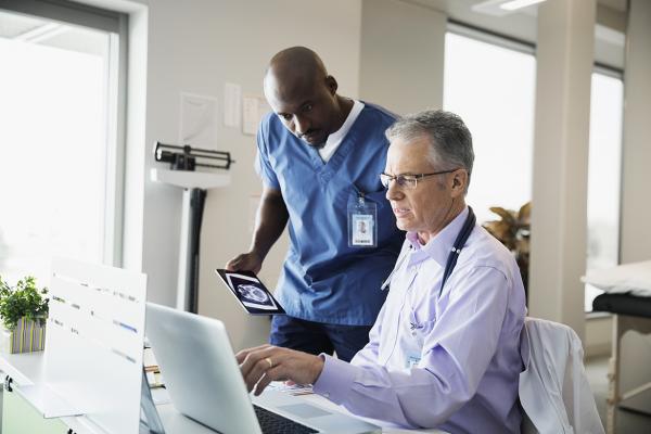Two physicians viewing a computer screen.