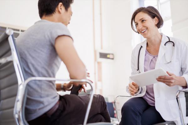 Smiling physician sitting down with patient