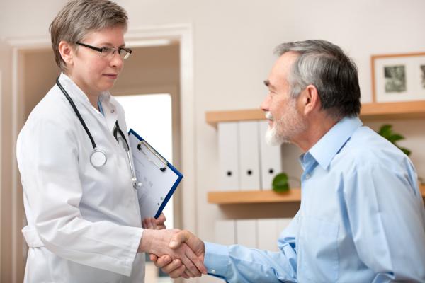 A physician shakes hands with her patient.