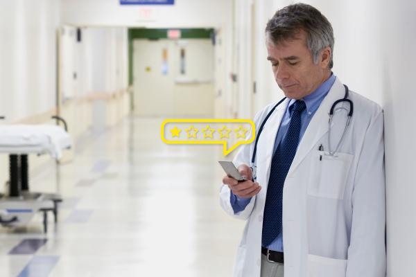 Physician monitors online review on his mobile device.