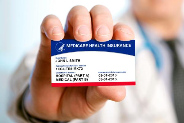 A man holding an example of a Medicare card.