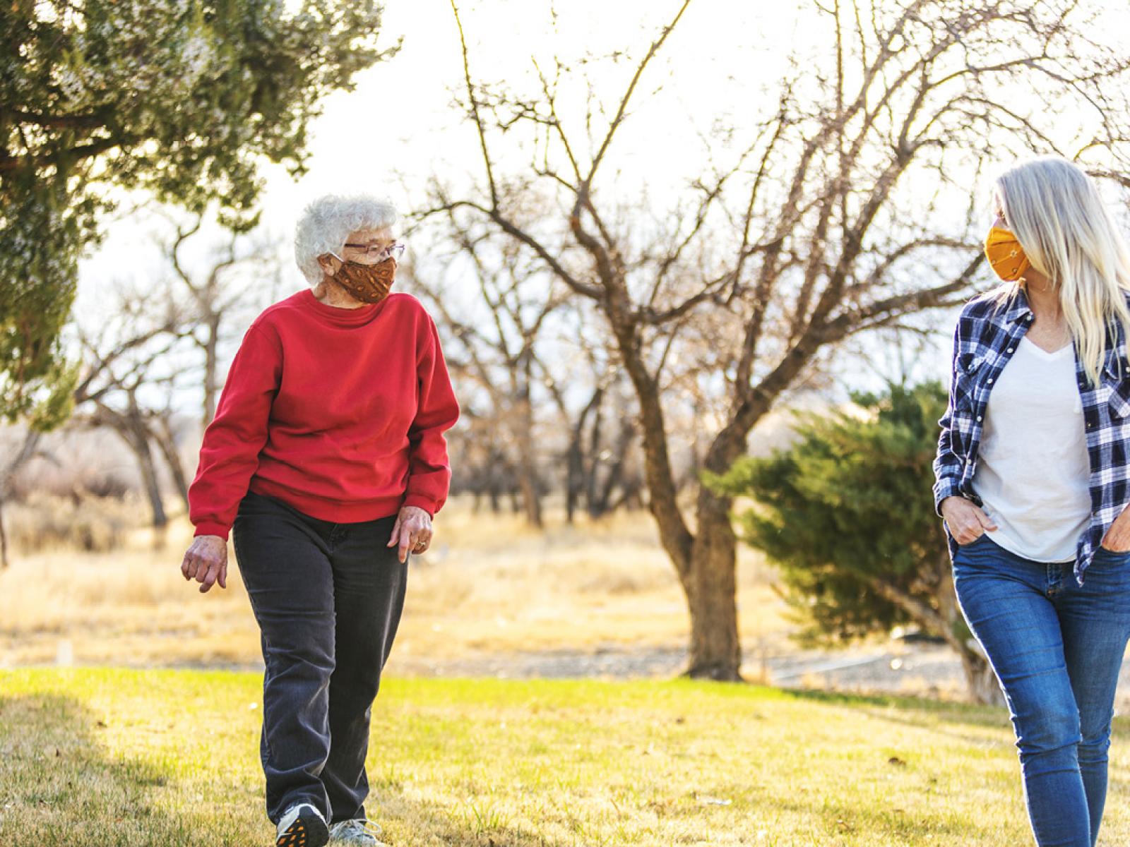 Two people wearing face masks taking a walk
