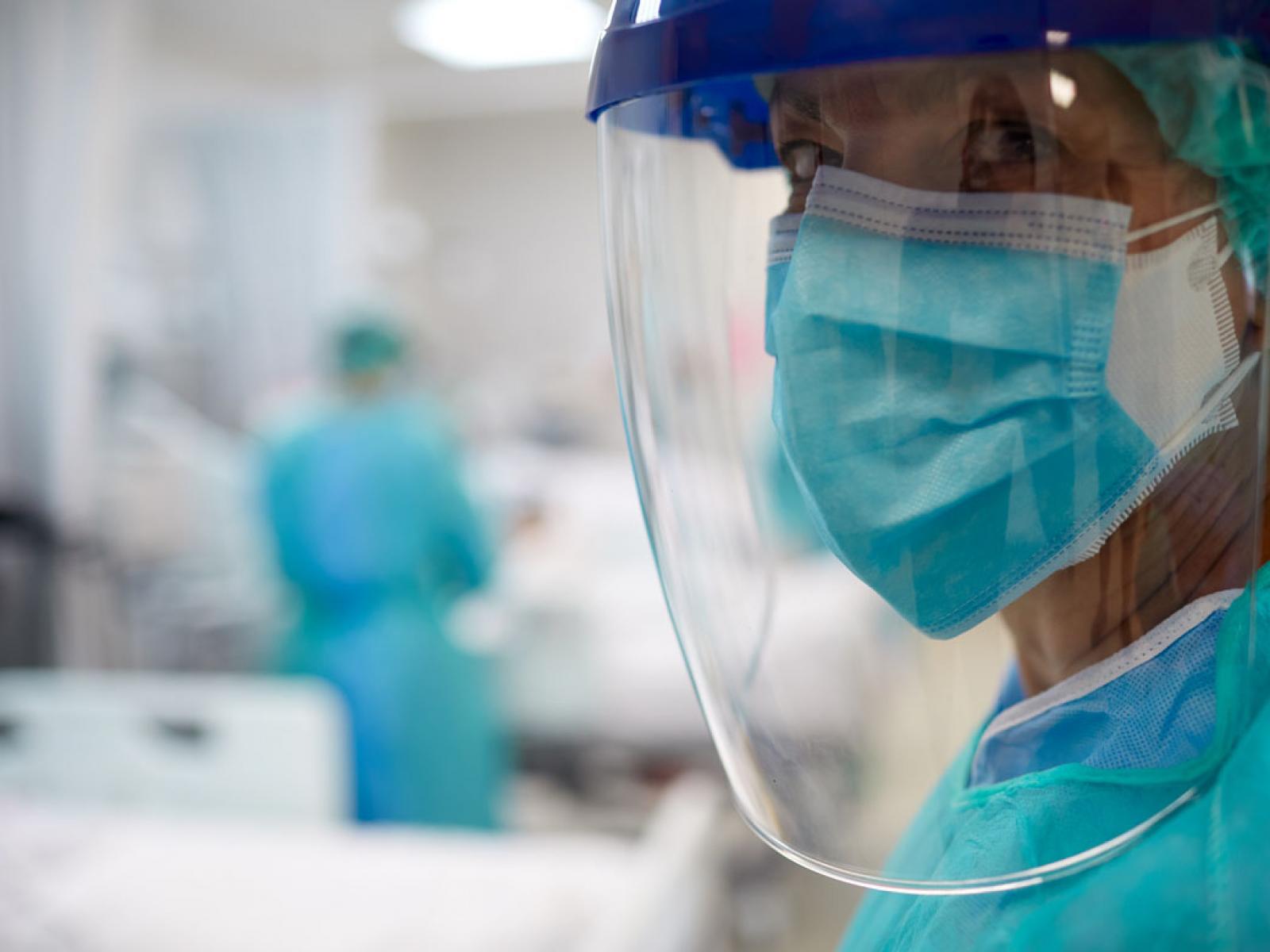 Physician with PPE, including mask, face shield and scrubs_Tight shot right framed