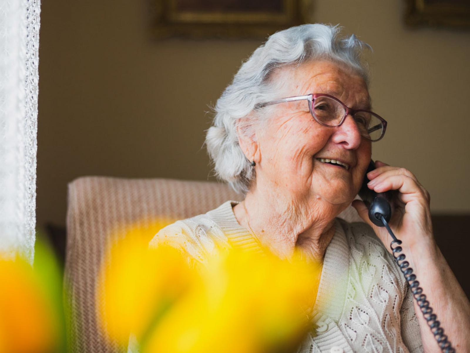 Smiling elderly person talking on the phone