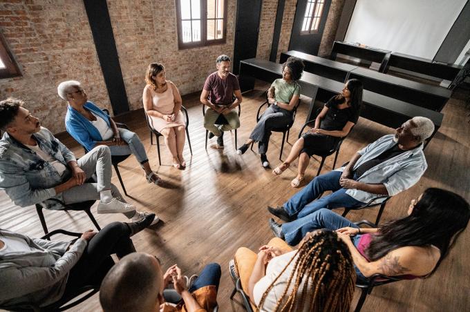 A support group sitting in a circle having a discussion