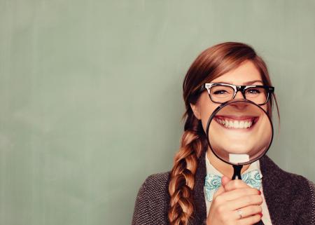 Woman smiling behind magnifying glass