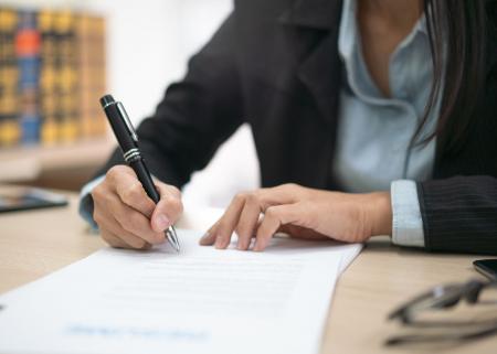 Tight shot of woman writing on sheet of paper