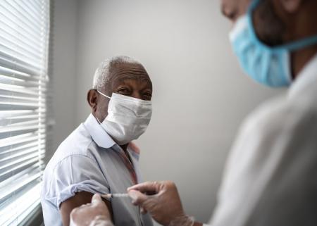 Nurse applying vaccine on patient's arm