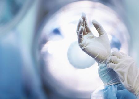 Surgeon adjusting gloves in operating room