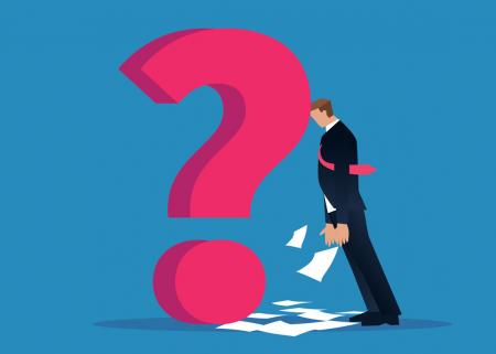 Businessperson leaning on a question mark