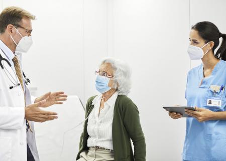 Health care workers speaking with patient