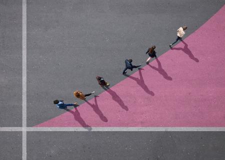 Group of people walking on painted tarmac surface