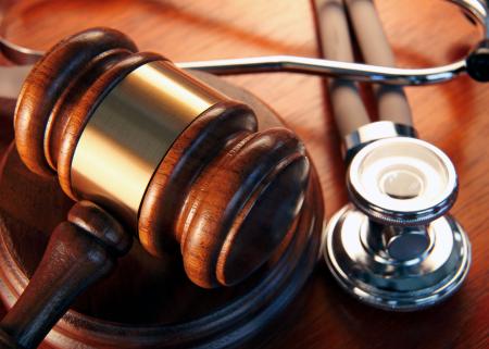 Close-up of gavel and scope resting on a desk.