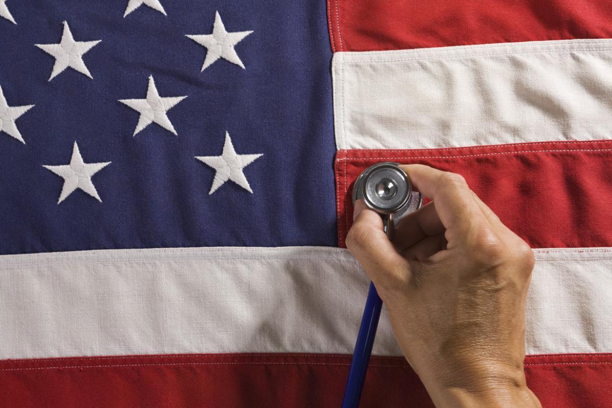 Person holding a stethoscope against American flag