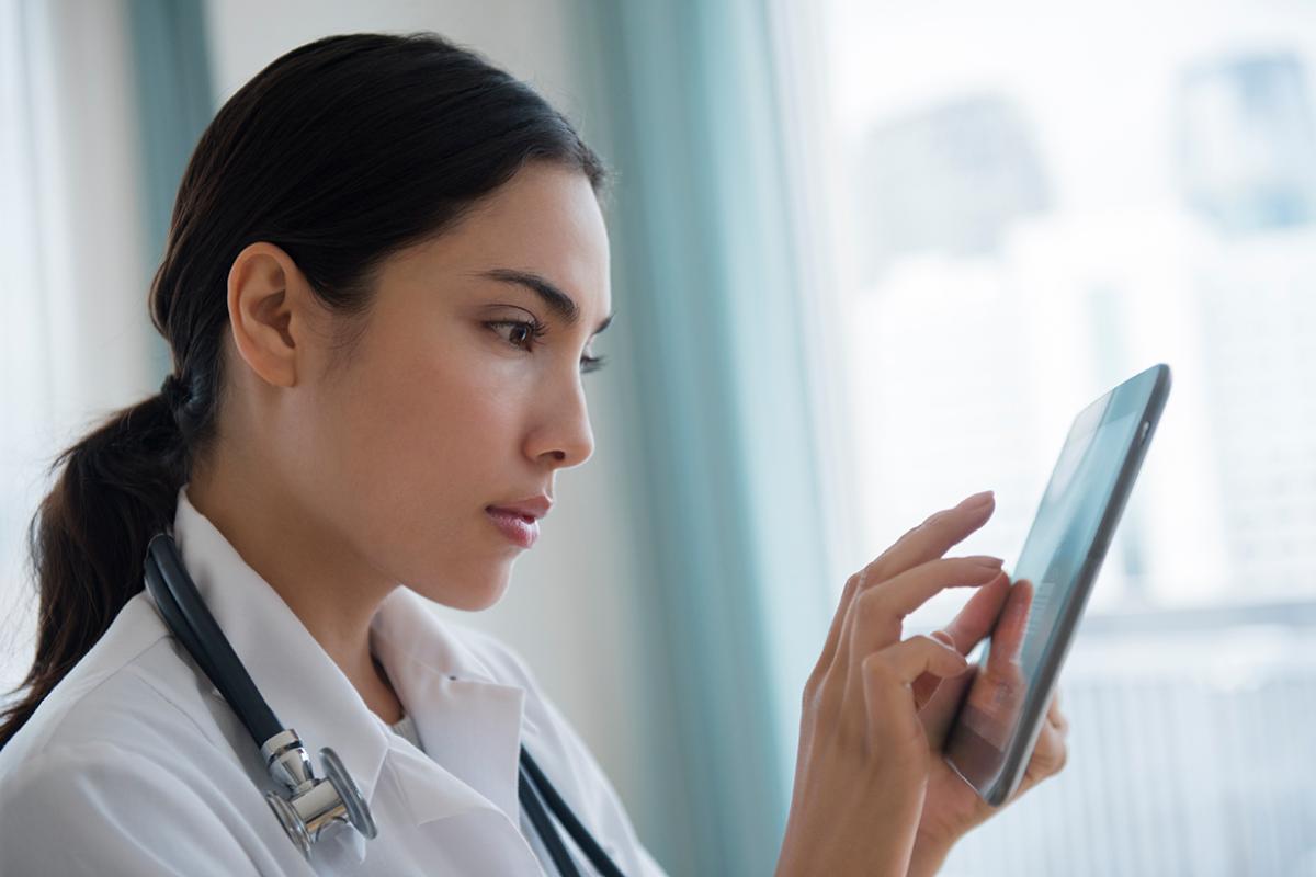 Physician on tablet reviewing information