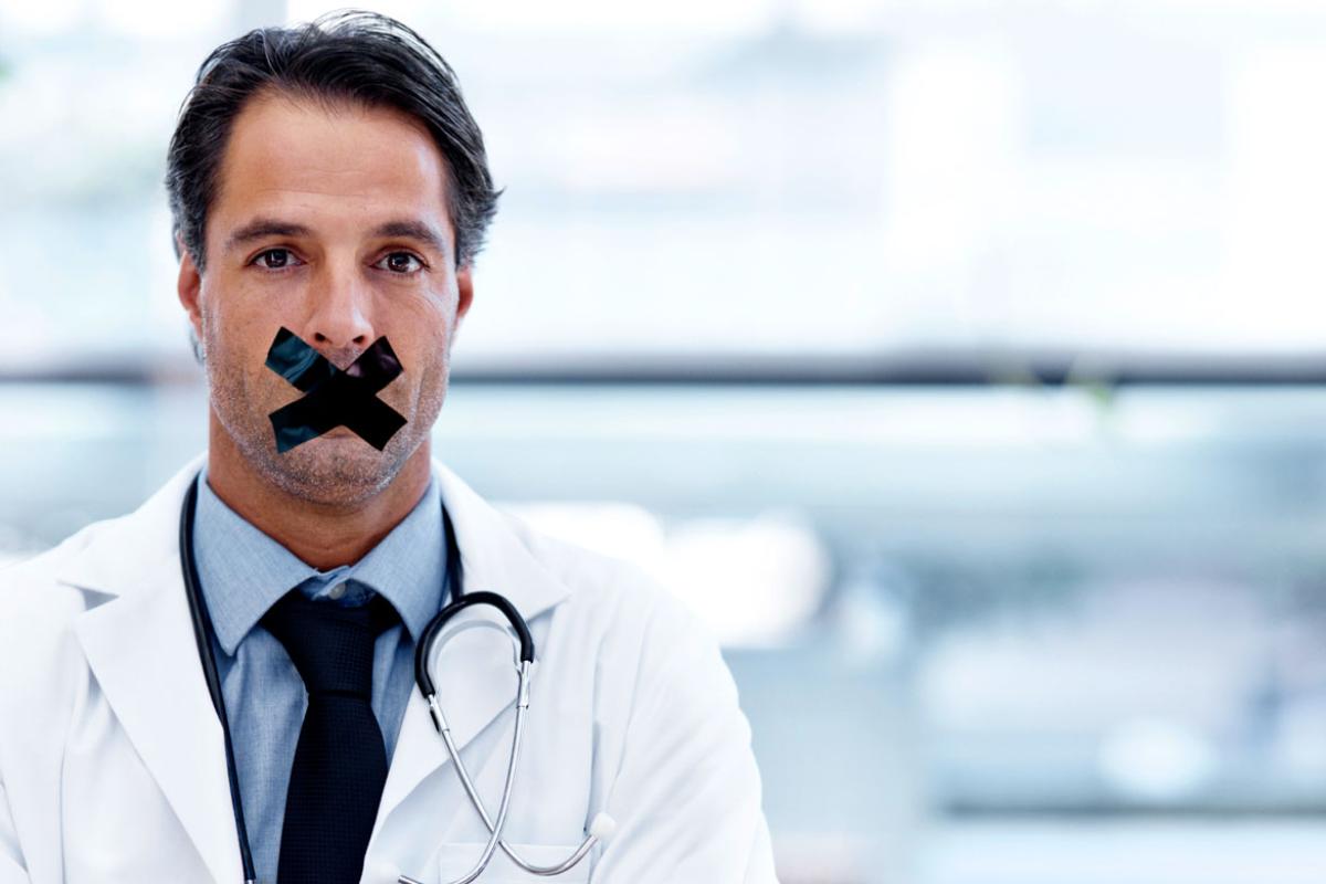 Physician with tape over his mouth