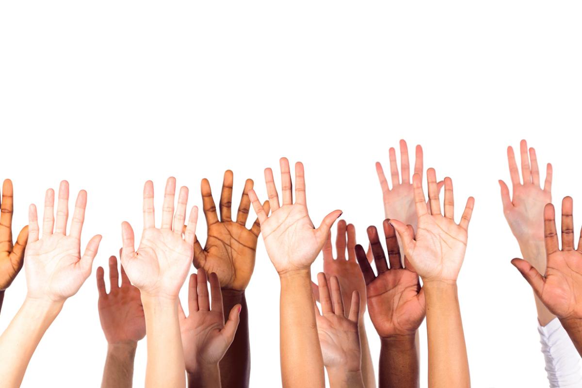 Group of people with hands raised to volunteer 