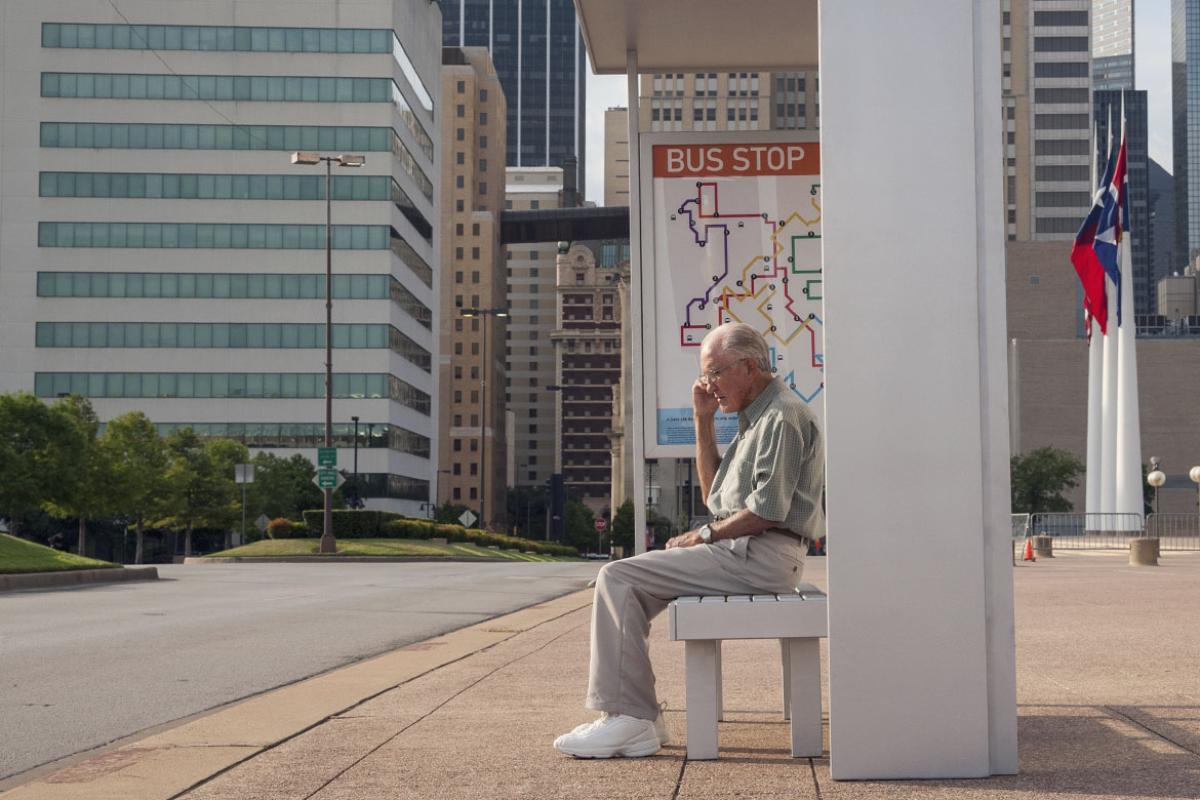 Older man waiting at a bus stop