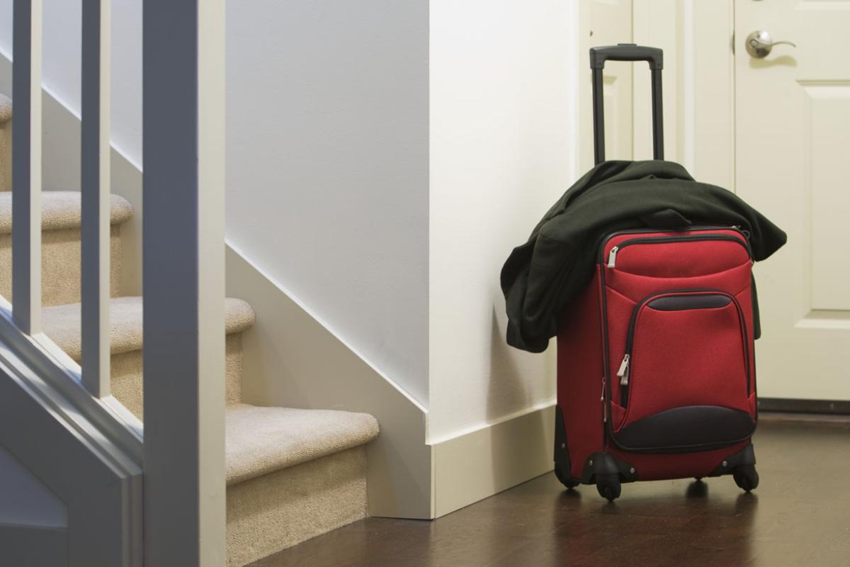 Suitcase and jacket in the foyer of a personal home